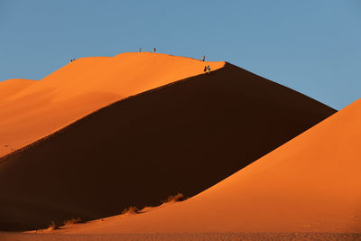 Scenic view of desert against clear sky during sunset