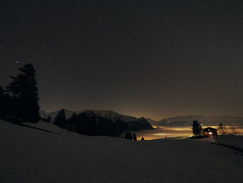 Scenic view of snow covered mountains against clear sky at night