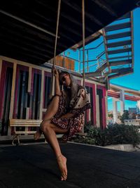 Full length of young woman sitting on swing