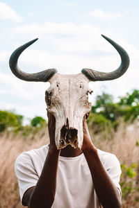 Portrait of a young adult holding animal skull