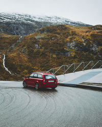 Car on road against snowcapped mountains against sky