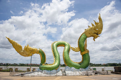 Low angle view of dragon statue against sky