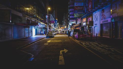 Road amidst buildings in city at night