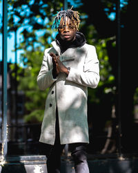 Portrait of senior man holding camera outdoors