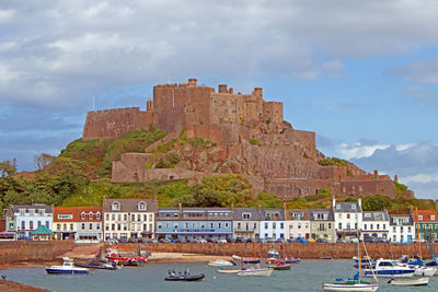 Buildings by sea against sky