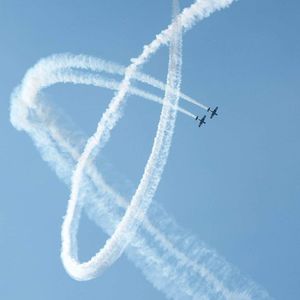 Low angle view of airplanes during airshow against blue sky