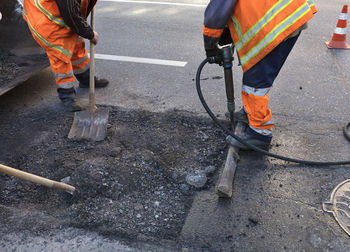 Low section of men working standing on road