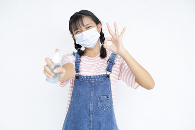 Full length of girl standing against white background