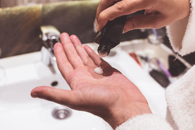 Cropped hands of woman applying moisturizer