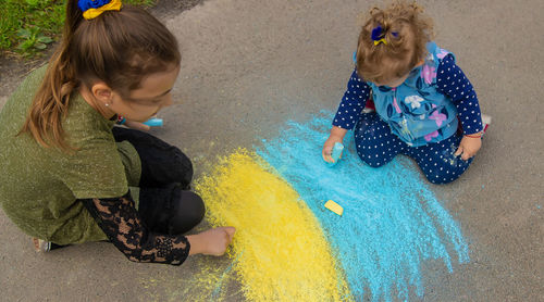 High angle view of girl playing with straw