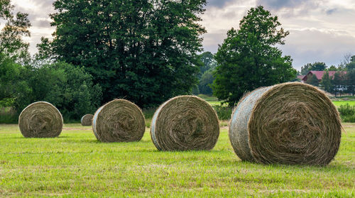 Hay bales on field against sky