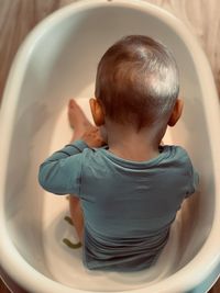 Boy sitting in bathtub at home