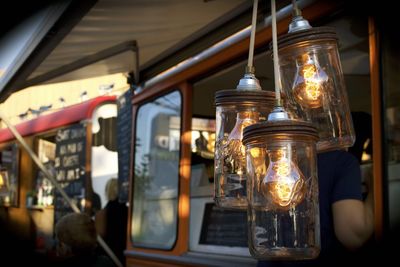 Light bulbs in glass containers hanging outside food truck