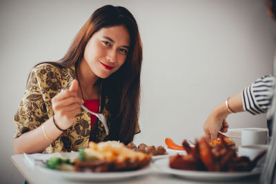 Portrait of smiling young woman having food