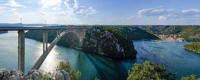 Arch bridge over river against sky