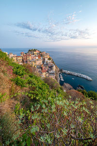 High angle view of townscape by sea against sky