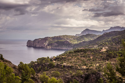 Scenic view of sea and mountains against sky
