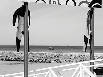 Deck chairs on beach against sky