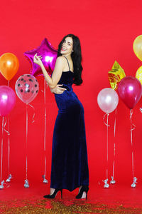 Full length of a smiling young woman with balloons