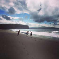 People walking on beach against sky