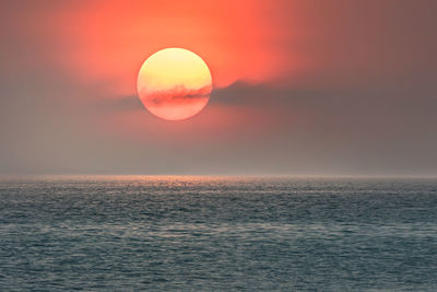 Scenic view of sea against romantic sky at sunset