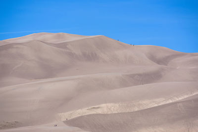 Scenic view of desert against blue sky