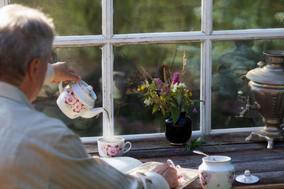 Rear view of man on table by window