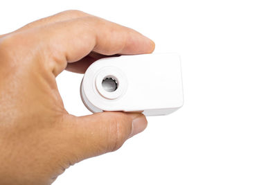 Close-up of hand holding camera over white background