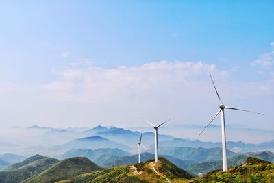 Wind turbines in mountains against blue sky