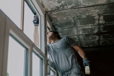 One young builder is repairing a window frame. person