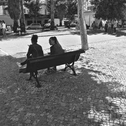 Rear view of man sitting on bench in park