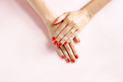 Cropped hand of woman gesturing against white background