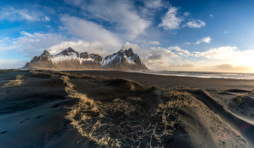 Scenic view of mountains by sea against sky during winter