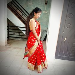 Woman with red umbrella standing on tiled floor