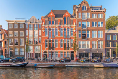 Buildings by canal against sky