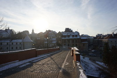 Street amidst buildings in town against sky