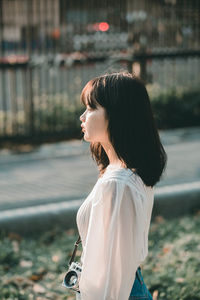 Side view of young woman looking at camera