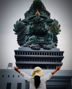 Rear view of woman statue against building