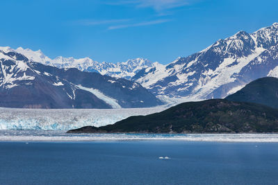 Scenic view of sea and snowcapped mountains against sky