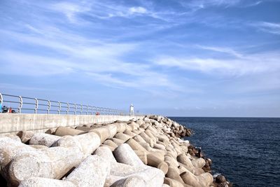 Rocks by sea against blue sky