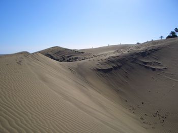 Scenic view of sand dunes against clear sky