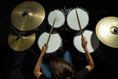 Rear view of woman playing drum