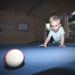 Portrait of boy playing with ball at table