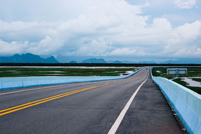 Empty road against cloudy sky