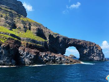 Rock formations by sea against sky