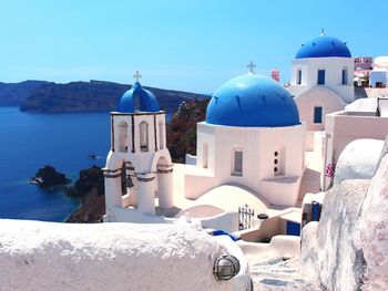 Traditional building by sea against blue sky