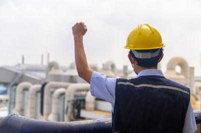 Rear view of man standing against railing