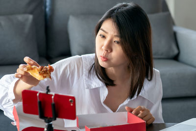 Portrait of woman looking away while sitting on table