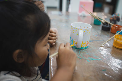 Cute girl making decoration on table