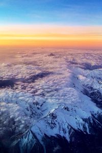 Scenic view of snow covered mountains at sunset